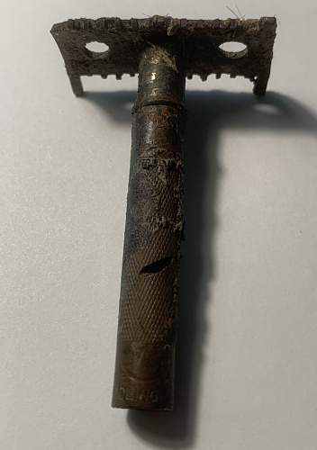 German razor with hairs from the soldier who used it still stuck in the blade area, as well as shrapnel damage