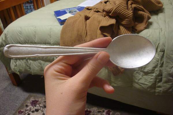 What could EK 127 mean if it is scratched into a spoon?