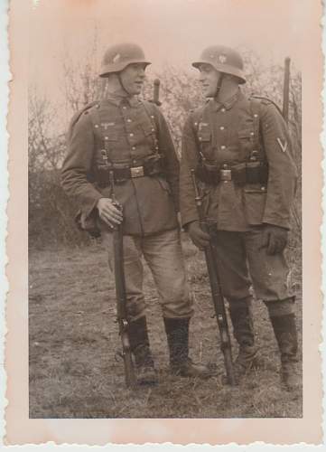 2 soldiers in uniform having a  conversation.