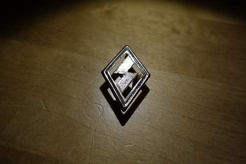 Unknown small diamond shape logo with safety pin?