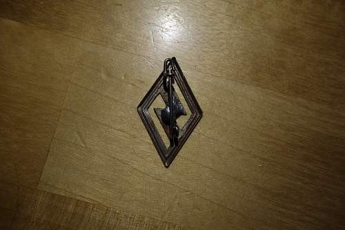 Unknown small diamond shape logo with safety pin?
