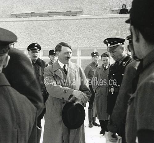 Himmler and Wolff in grey overcoat with black collar and black cap....