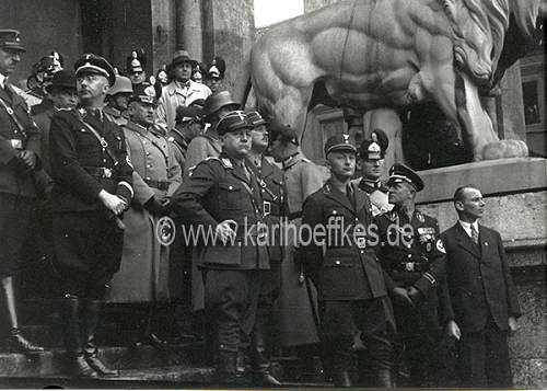 Himmler and Wolff in grey overcoat with black collar and black cap....